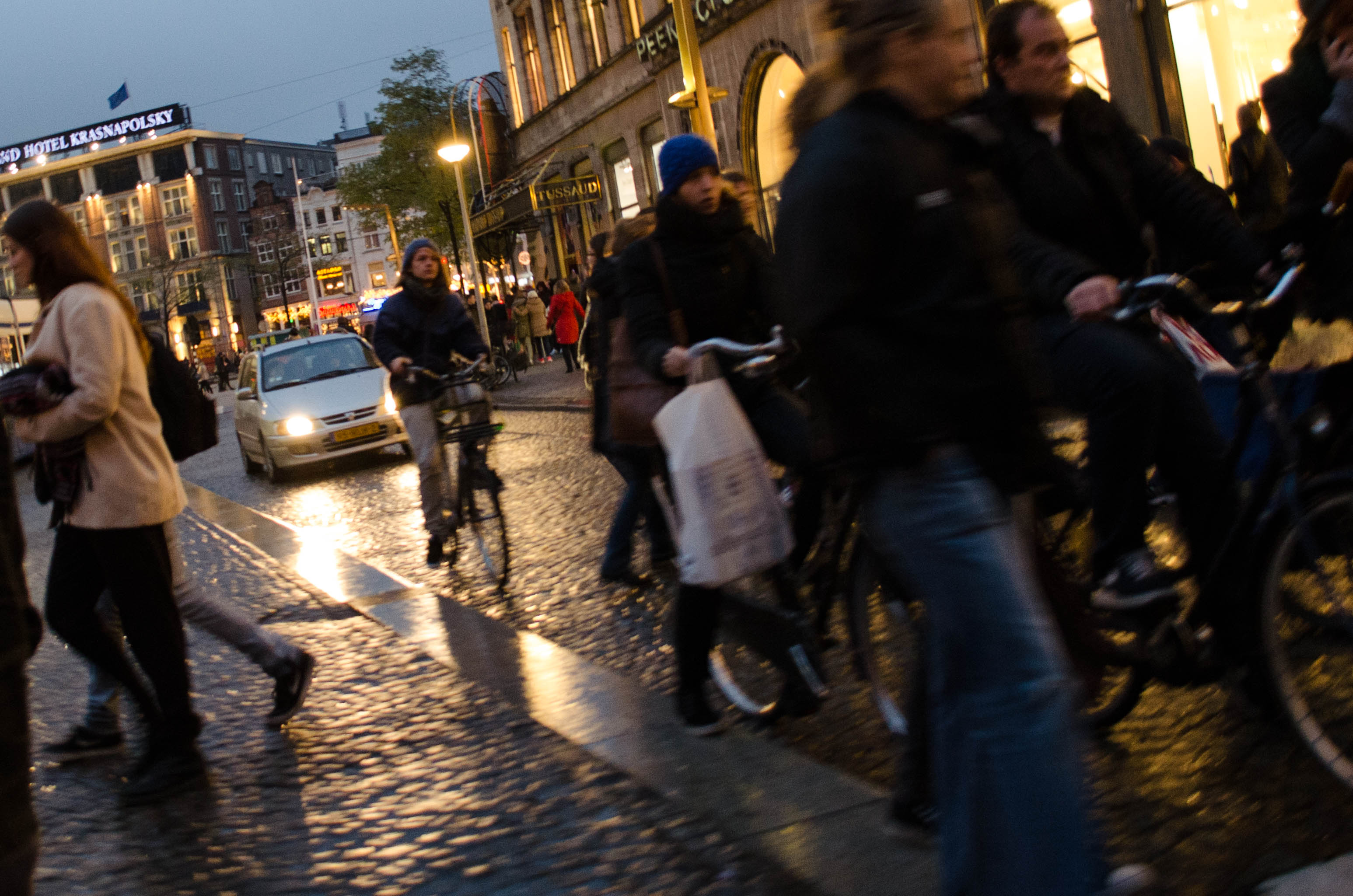cyclists and pedestrians attempt to navigate the busy street in Dam Square Amsterdam