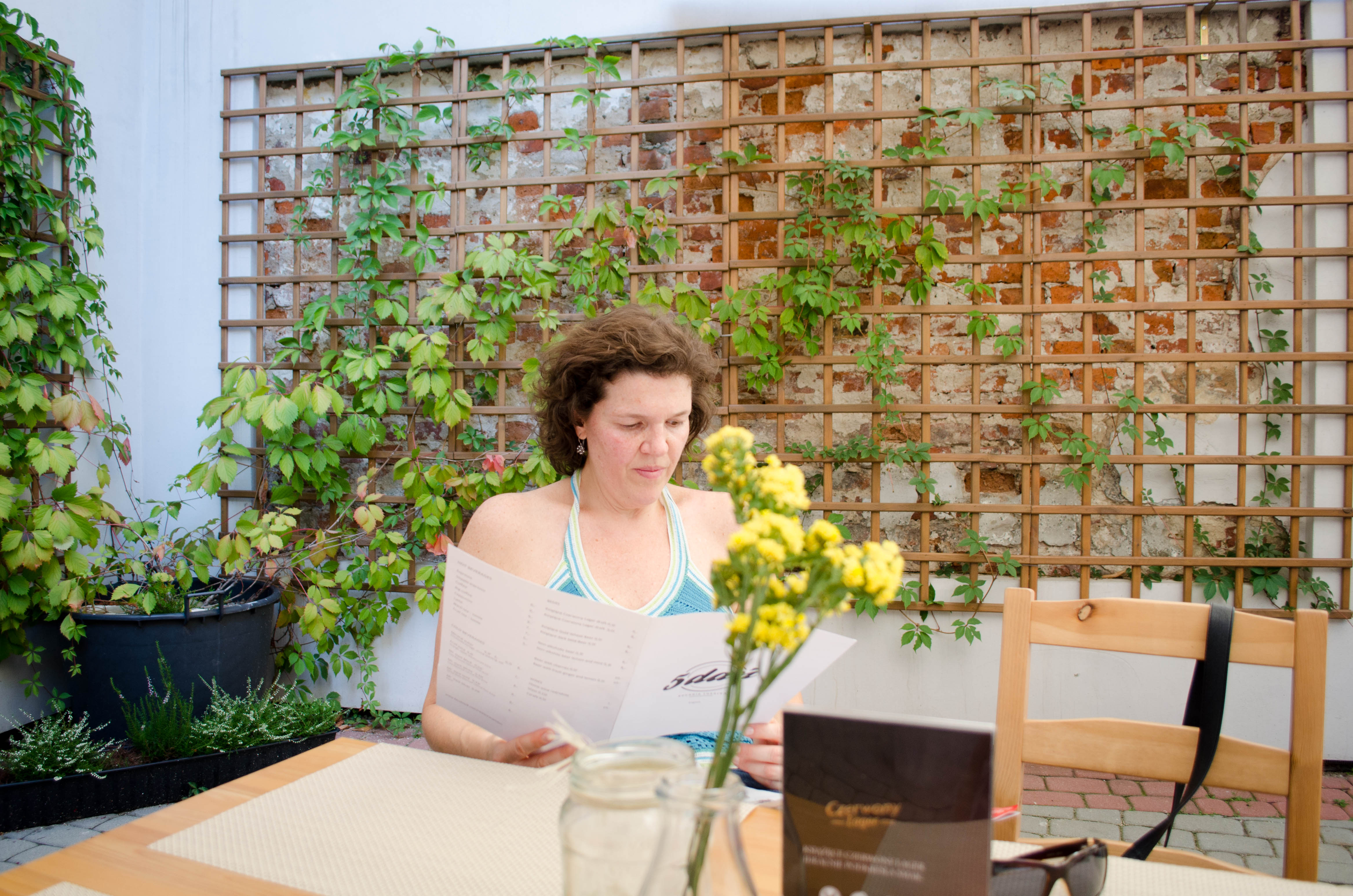 A woman ponders the menu at a beautiful outdoor café in Krakow, Poland.